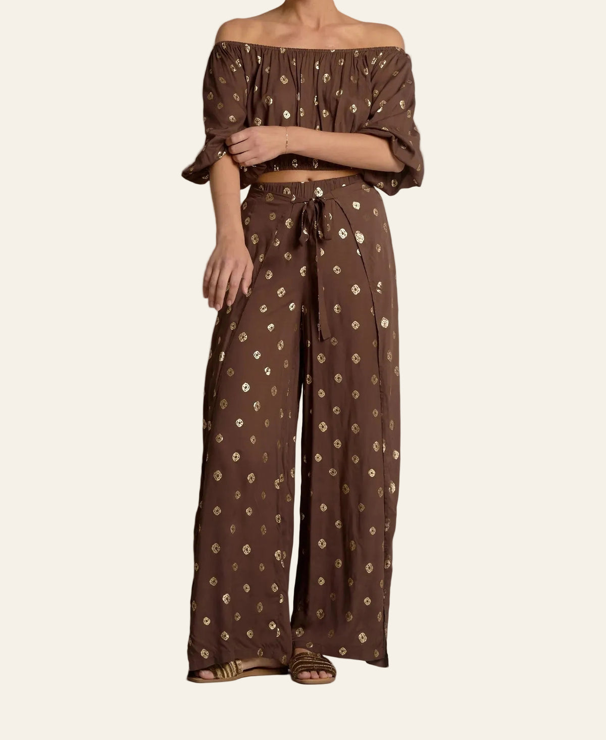 Brown patterned off-shoulder top and wide-leg pants on a neutral background