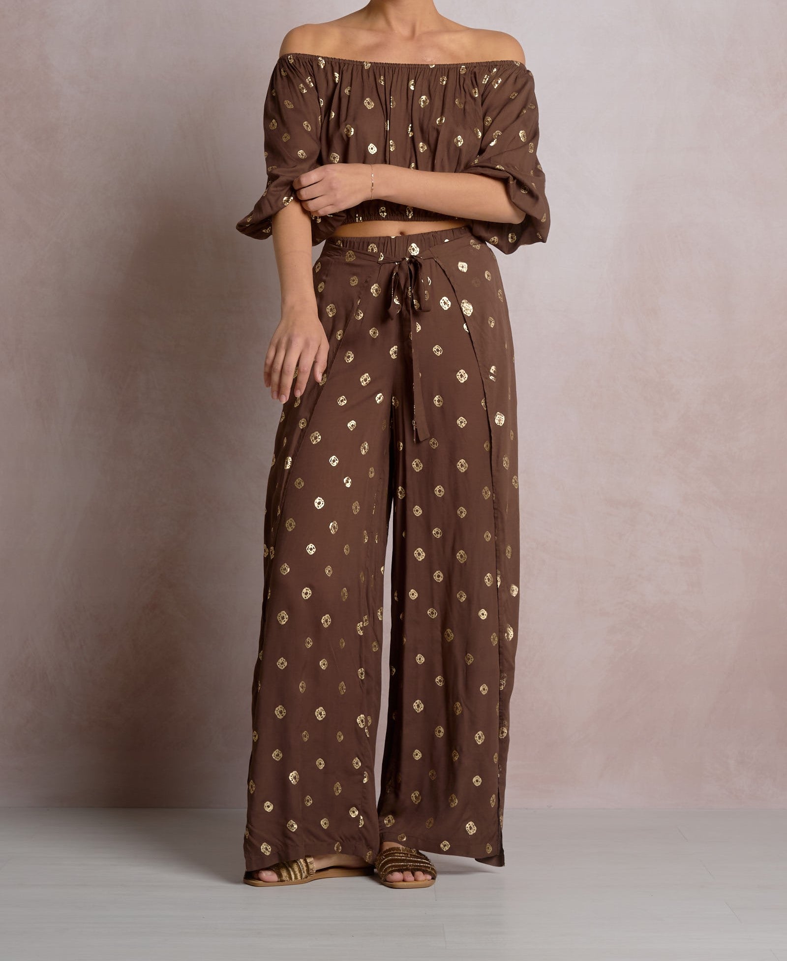 Brown patterned off-shoulder top and wide-leg pants on a neutral background